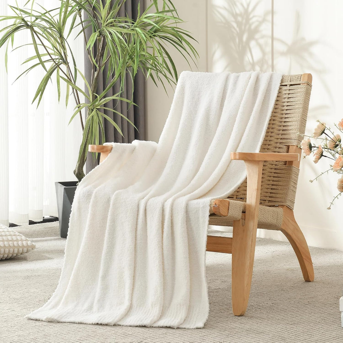 Lightweight cream throw blanket on a bed