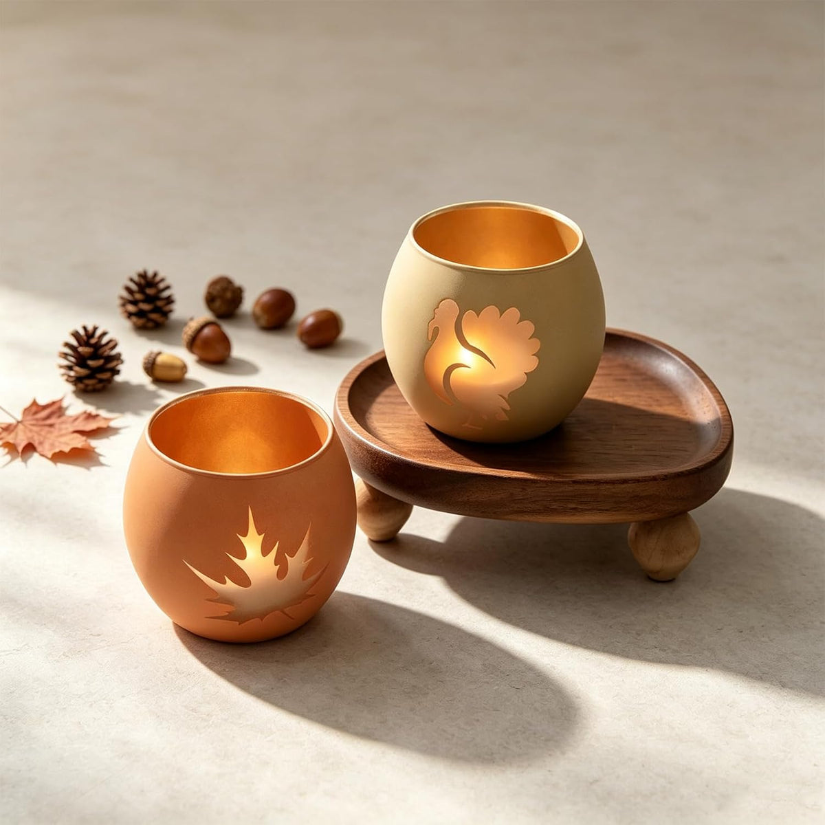 Lit Thanksgiving tealight holders on a dining table
